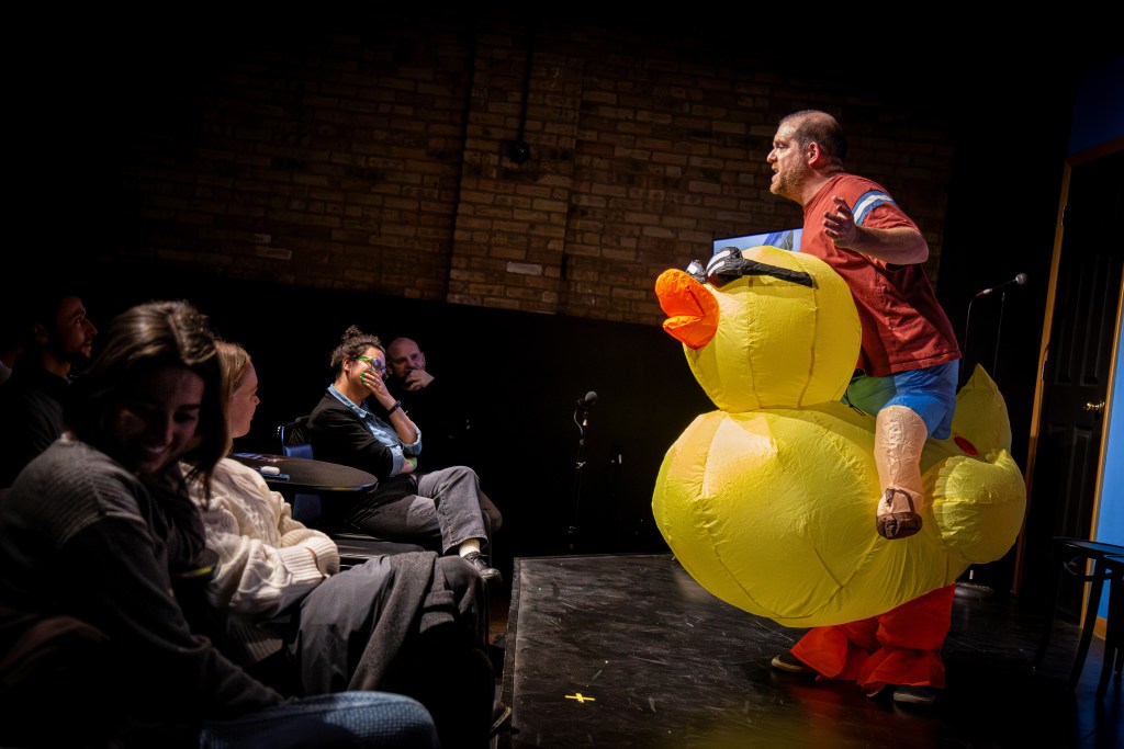 Bob on stage in inflatable duck costume at Sketchfest Chicago